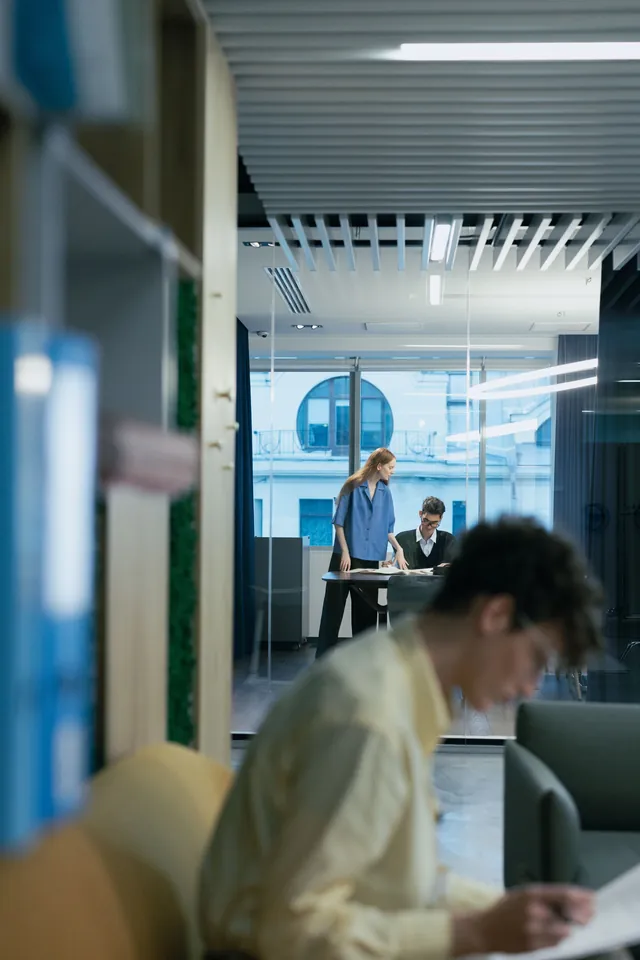 Collaborateurs au travail dans un bureau vitré