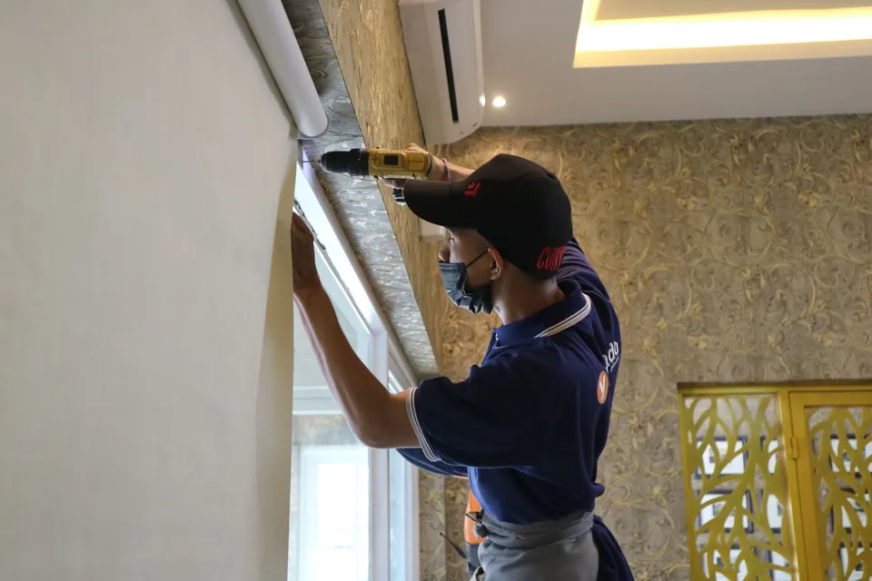 Technicien installant un équipement au-dessus d’une porte