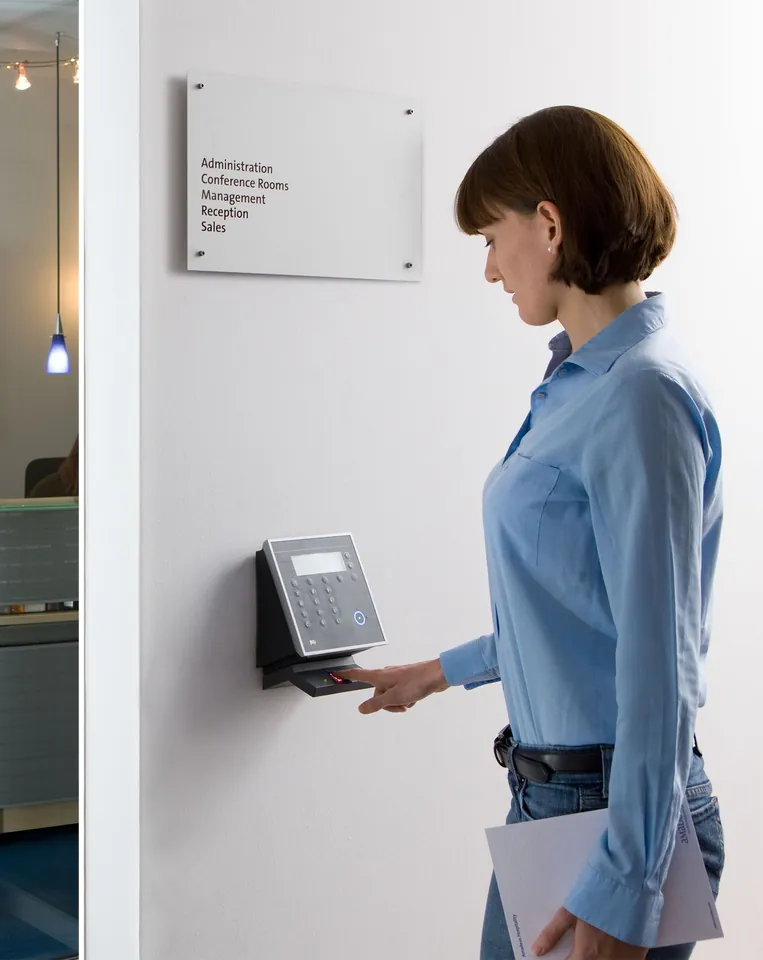 Une collaboratrice présente son badge au lecteur à l’entrée des bureaux