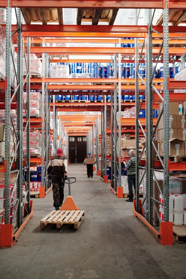 Allée d’un entrepôt logistique avec des opérateurs au travail